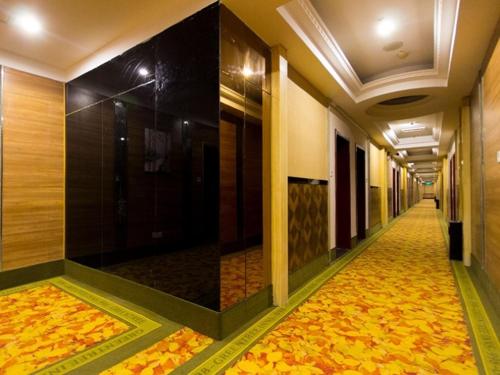 a hallway of a hotel with a walkway with a floor covered in leaves at GreenTree Inn Henan Zhengzhou Chengnan Road Bojue Business Hotel in Zhengzhou