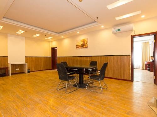 a conference room with a table and chairs in it at GreenTree Inn Henan Zhengzhou Chengnan Road Bojue Business Hotel in Zhengzhou