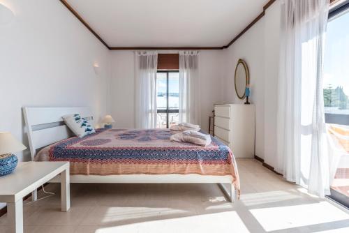 アルマカオ・デ・ペラにあるFish House Flatの白いベッドルーム(ベッド1台、窓付)