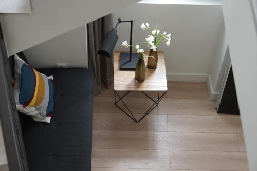 a table with two vases with flowers on it at MD Design Hotel - Portal del Real in Valencia