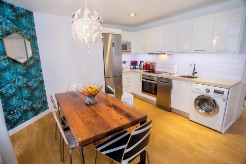 a kitchen with a wooden table and a refrigerator at Superb Apartament Canteras in Las Palmas de Gran Canaria