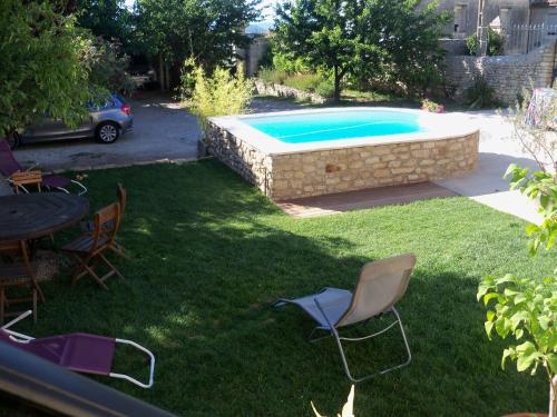a yard with a pool and chairs and a table at La Migrane in Villevieille
