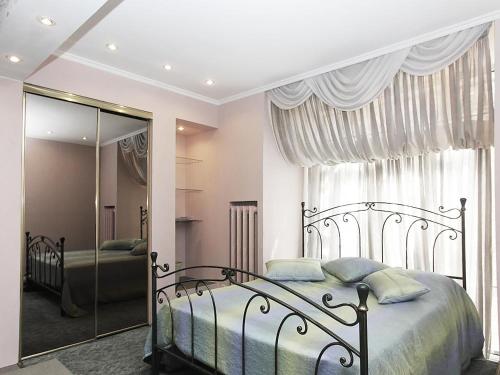 1 dormitorio con 1 cama grande y espejo en ApartLux Tverskaya, en Moscú