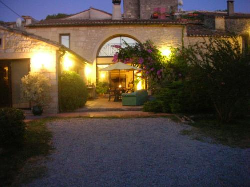 a house with a patio at night with lights at La Migrane in Villevieille