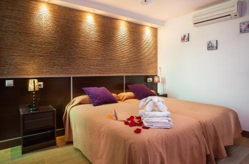 a bedroom with a bed with towels on it at Hostal Casa Mercedes in Nerja