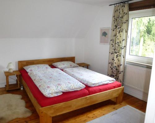 a bedroom with a bed with a red blanket and a window at Schwalbennest in Geesthacht