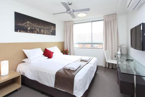 um quarto de hotel com uma cama e uma televisão em PA Apartments em Brisbane