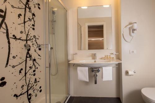 y baño con lavabo y ducha. en Hotel American Palace Eur, en Roma