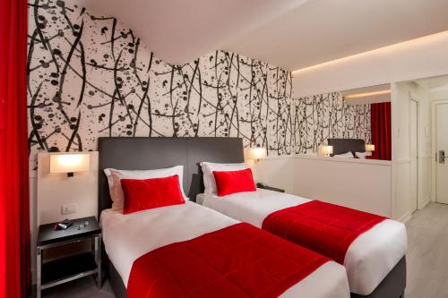 two beds in a hotel room with red pillows at Hotel American Palace Eur in Rome