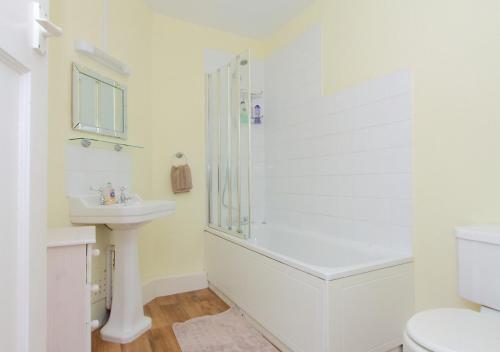 baño blanco con ducha y lavamanos en Large Cosy House Ideal for Corporate Lets, en Andover