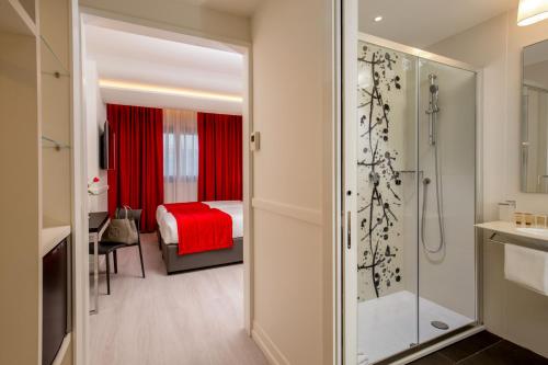 a bathroom with a shower and a bedroom at Hotel American Palace Eur in Rome