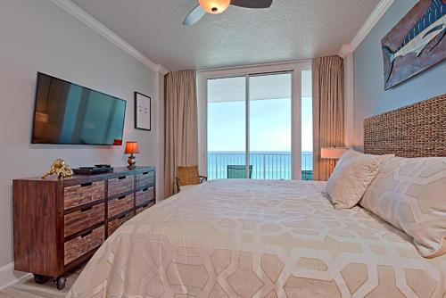 um quarto com uma cama grande e uma televisão de ecrã plano em Lighthouse 714 em Gulf Shores