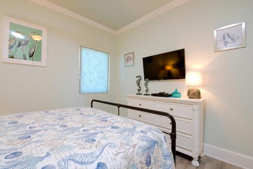 a bedroom with a bed and a flat screen tv at Lighthouse 714 in Gulf Shores