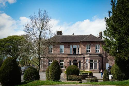 an old brick house with bushes in front of it at Whiston Hall in Whiston