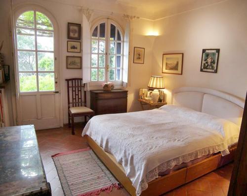 a bedroom with a large bed and a table and window at La Casa nel Bosco in Capri