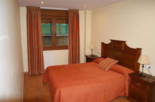 Las RozasにあるApartamentos Don Clementeのベッドルーム1室(オレンジ色のベッド1台、窓付)