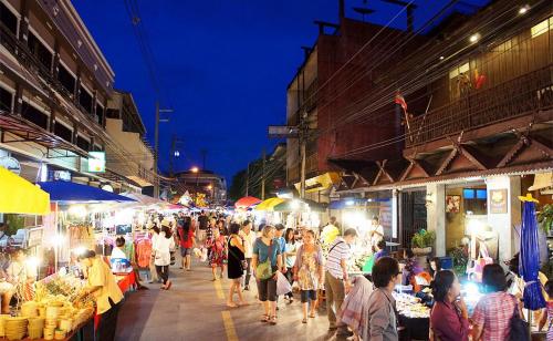 a crowd of people walking through a market at night at Aphilapa Residence in Chiang Mai