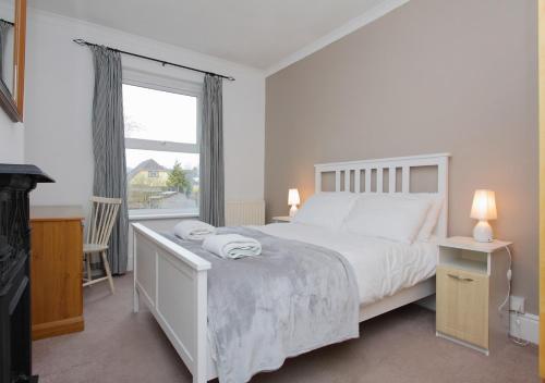 a white bedroom with a bed and a window at Lovely Victorian House in Andover