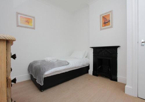 a bedroom with a bed and a fireplace at Lovely Victorian House in Andover