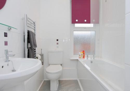 Lovely Victorian House في أندوفر: حمام أبيض مع مرحاض وحوض استحمام ومغسلة