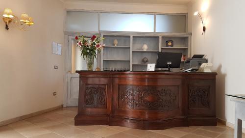 a desk with a vase of flowers on top of it at Relais Sant'Eligio in Ostuni