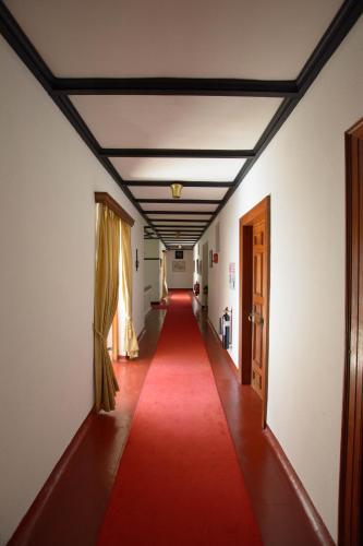 a long corridor with a red carpet in a hallway at Governor's Mansion in Hatton