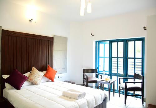 a bedroom with a bed and a table and chairs at Hydrangea Villa in Kodaikānāl
