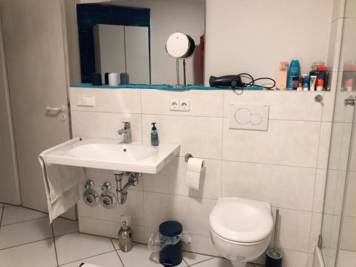 a bathroom with a toilet and a sink and a mirror at Gästezimmer bei Ingrid in Tübingen
