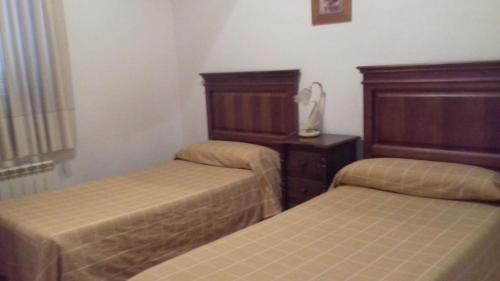a room with two beds and a dresser at Casa Rural del Río Tejos in El Hornillo