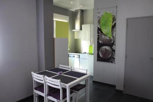 a kitchen with a table and chairs in a room at Appartement Les Confidences in Le Touquet-Paris-Plage