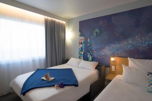 a hotel room with two beds with a tray with a pair of shoes at Novotel Chartres in Chartres