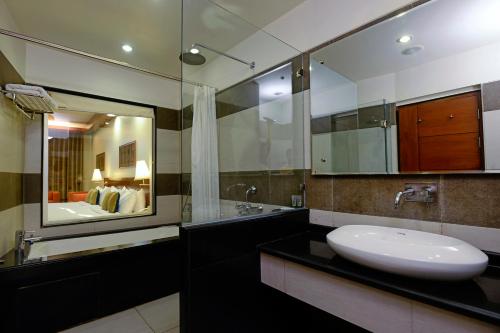 La salle de bains est pourvue d'un lavabo et d'un grand miroir. dans l'établissement Elevate by TreeHouse, à Bhiwadi
