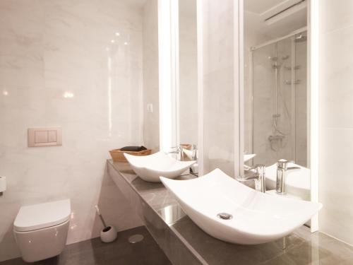 uma casa de banho com 2 lavatórios e um WC em Apartamento nuevo y de lujo en puerta del sol em Madri
