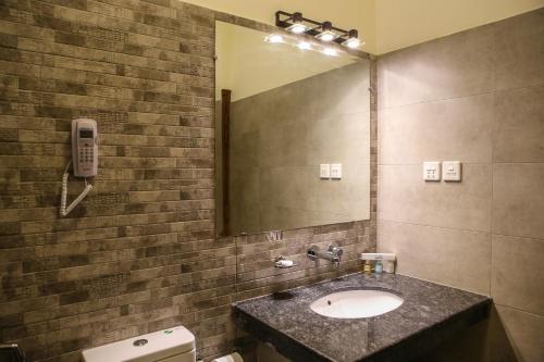 ein Bad mit einem Waschbecken und einem Spiegel in der Unterkunft Dreamworld Resort, Hotel & Golf Course in Karatschi