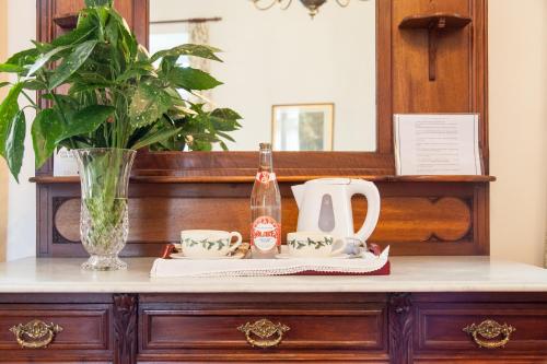 a dresser with a mirror and a tea kettle and cups at Hotel Casona El Arral in Liérganes