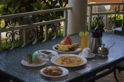 a table topped with plates of food on a balcony at Step Town in Kigali