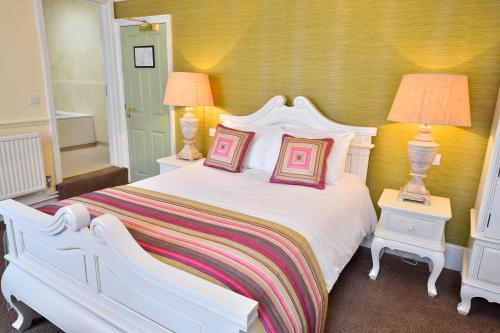 a white bed with two pillows on it in a bedroom at The Angel Hotel in Coleford