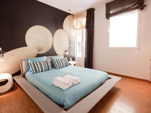 um quarto com uma cama grande e lençóis azuis em Gran apartamento de diseño @plazasanmiguel *lujo* em Madri