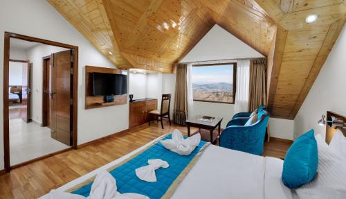 a bedroom with a large bed and a large window at Hotel The Twin Towers in Shimla