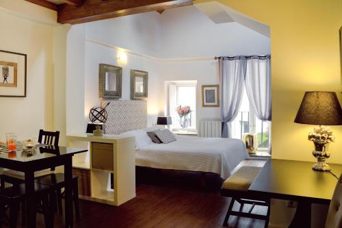 a bedroom with a bed and a table and a desk at Inicia Casas Reales in Santiago de Compostela