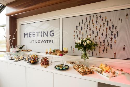 a buffet of food on a white counter at Novotel Chartres in Chartres