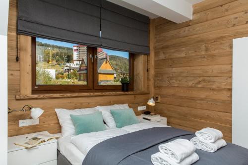 ein Schlafzimmer mit einem großen Bett und einem Fenster in der Unterkunft Apartament Przy Stoku - Polana Szymoszkowa Ski Resort in Zakopane