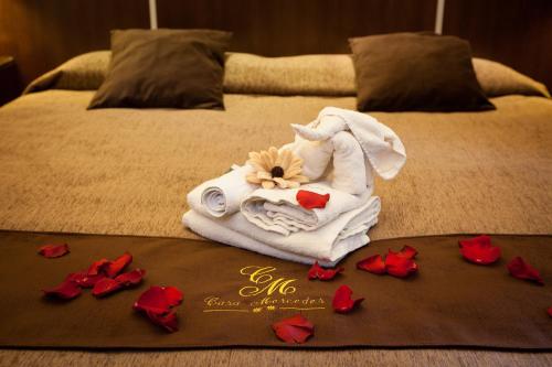 a towel on a bed with red flowers on it at Hostal Casa Mercedes in Nerja