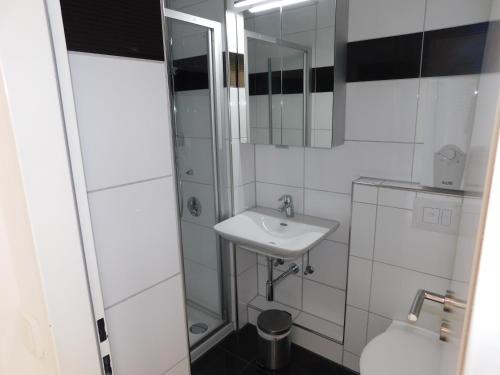 een witte badkamer met een wastafel en een spiegel bij Wohnung Sonnenschein inkl Strandkorb vom 01 05-01 10 in Grömitz