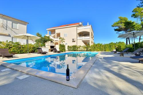 a swimming pool with a bottle of wine next to a house at Mam in Vir