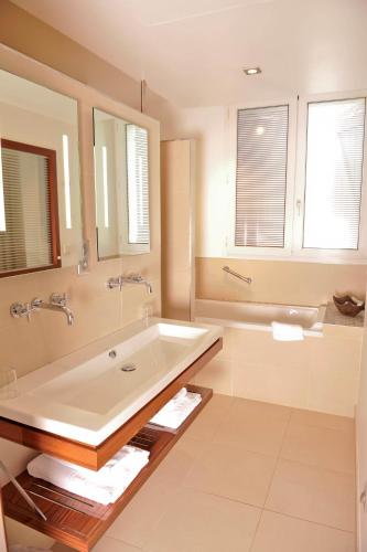 a bathroom with a large sink and a tub at Hôtel des Pyrénées in Saint-Jean-Pied-de-Port