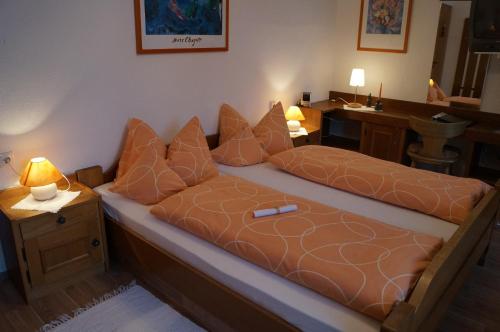 a bedroom with a bed with pillows on it at Ferienhotel Barmsee in Krün
