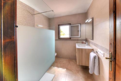 a bathroom with a shower and a sink and a mirror at Villa Dos Pinos in Cala d´Or