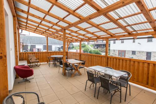 a patio with tables and chairs and a glass roof at Penzion Bedrč in Benešov