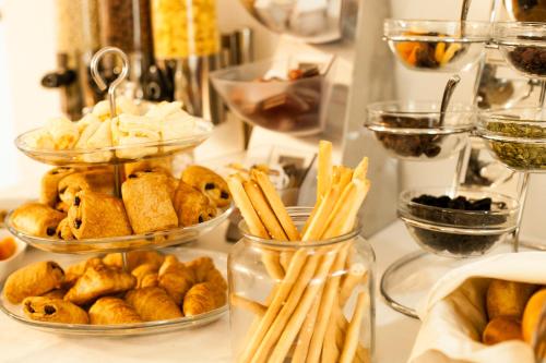 a buffet filled with different types of bread and pastries at Victoria Bulevard Hotel in Braşov